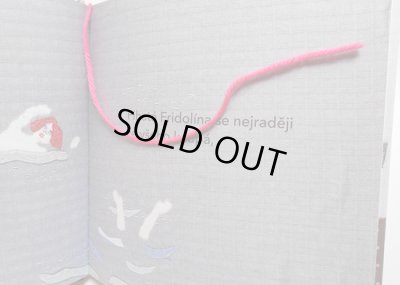 猫のミーカとミーナが遊んでいるピンクの毛糸が本のしおりになっています。