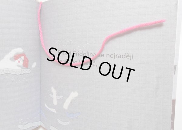 猫のミーカとミーナが遊んでいるピンクの毛糸が本のしおりになっています。